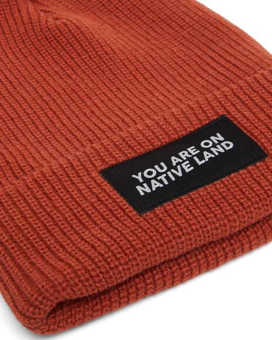 'YOU ARE ON NATIVE LAND' RIBBED BEANIE - REDWOOD